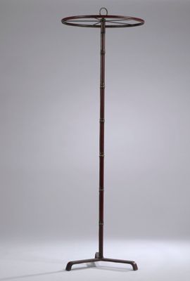 a tall wooden floor lamp with a metal base and a glass shade