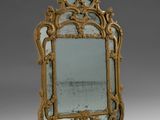 un miroir richement décoré, doté d'un cadre doré sur fond gris