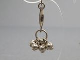 une paire de boucles d'oreilles plaquées argent sur un support en acrylique transparent