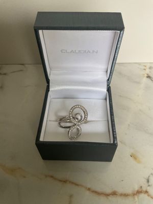 a close up of a ring in a box on a marble surface