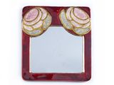 miroir rouge et or orné de deux roses sur fond blanc