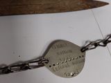 a metal chain with a tag on it and a pair of scissors