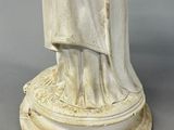 an antique statue of a woman holding a baby in her arms