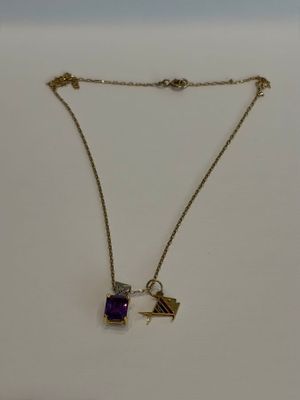 un gros plan d'un collier avec une pierre violette sur une chaîne