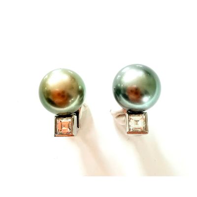 une paire de boucles d'oreilles en perles et diamants posées sur un fond blanc