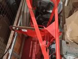 a picture of a red machine with a hose attached to it