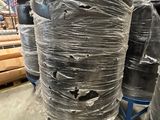 de nombreux rouleaux de plastique emballés sur une palette dans un entrepôt