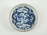 assiette bleue et blanche ornée d'un dragon sur fond blanc