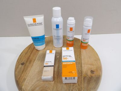 bottles of sunscreen and lotion sitting on a wooden tray on a table