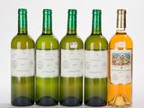 four bottles of wine are lined up on a white surface