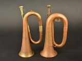 pair of antique brass trumpets on a black background
