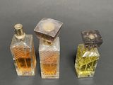 three bottles of perfume sitting next to each other on top of a table