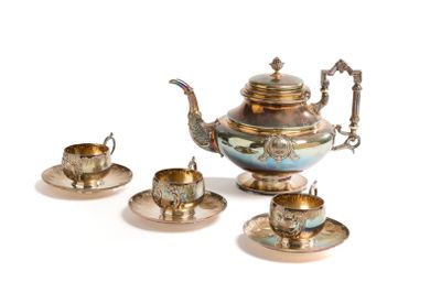 une théière en argent et deux tasses en argent posées sur une table