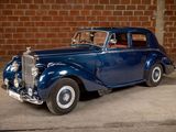 a blue car that is parked in front of a brick wall