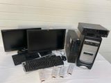 three computer monitors, a keyboard, and a monitor on a table