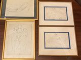 trois dessins encadrés représentant un homme et une femme, posés sur une table