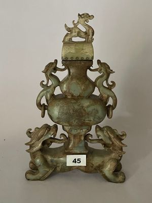 un vase en bronze surmonté d'un oiseau