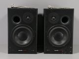 two black speakers sitting side by side on a white surface