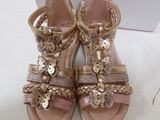 gold and pink sandals with bows and bows on them
