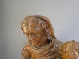 une statue en bois représentant une femme et un mouton