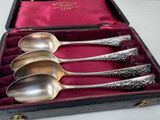 four spoons in a case with velvet lining