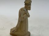 figurine of a man with a hat and robe on a white background