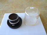a glass of water and a camera lens on a table