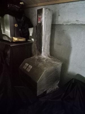 une photo d'une pièce avec un poêle et une poubelle
