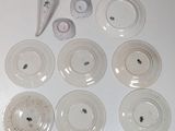 a white table topped with white plates and a white object