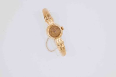 a close up of a gold watch on a white surface