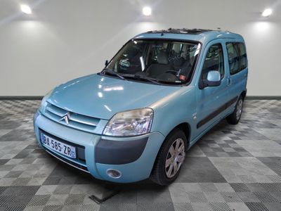 une petite camionnette bleue garée dans une pièce au sol à carreaux