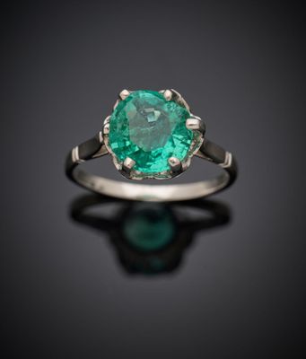 un gros plan d'une bague ornée d'une pierre verte sur un fond noir
