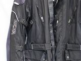 veste de moto noire et grise suspendue à un cintre sur fond blanc