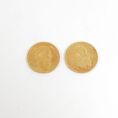 deux pièces d'or posées sur une surface blanche, sur fond blanc