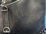 black leather handbag with a metal chain hanging from it ' s side