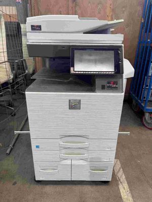 une imprimante blanche posée sur une pile de cartons