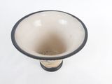 a black and white vase on a white surface