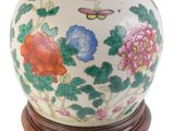 une image représentant un vase blanc orné de fleurs colorées et d'un papillon