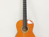 une guitare orange posée sur une surface blanche