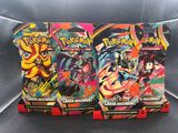 trois paquets de cartes Pokémon posés sur un canapé