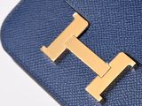 a close up of a blue purse with a gold t on it