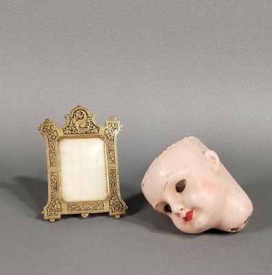 un petit cadre photo et une petite figurine posés sur une table
