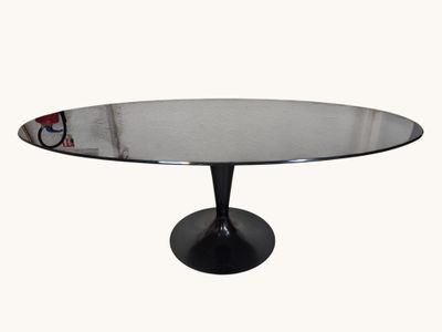 une table ronde en verre avec un piètement noir