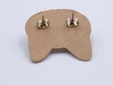 a close up of a pair of earrings on top of a piece of cardboard