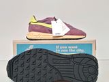 purple and yellow sneakers are on top of a box with a price tag