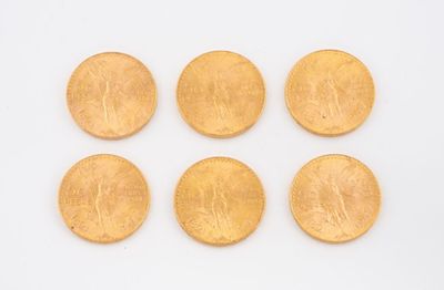 six pièces d'or sont disposées en ligne sur une surface blanche