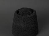 a small black bowl with a black top on a gray surface