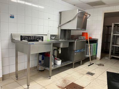 a kitchen with a sink, stove, and other items in it