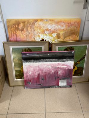 un tableau posé par terre, à côté d'un tableau accroché au mur