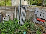a pile of pipes in the grass next to a building